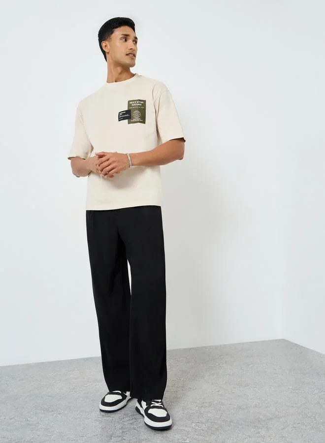 ستايلي تيشيرت بقصة واسعة وتفاصيل رقعة على الصدر